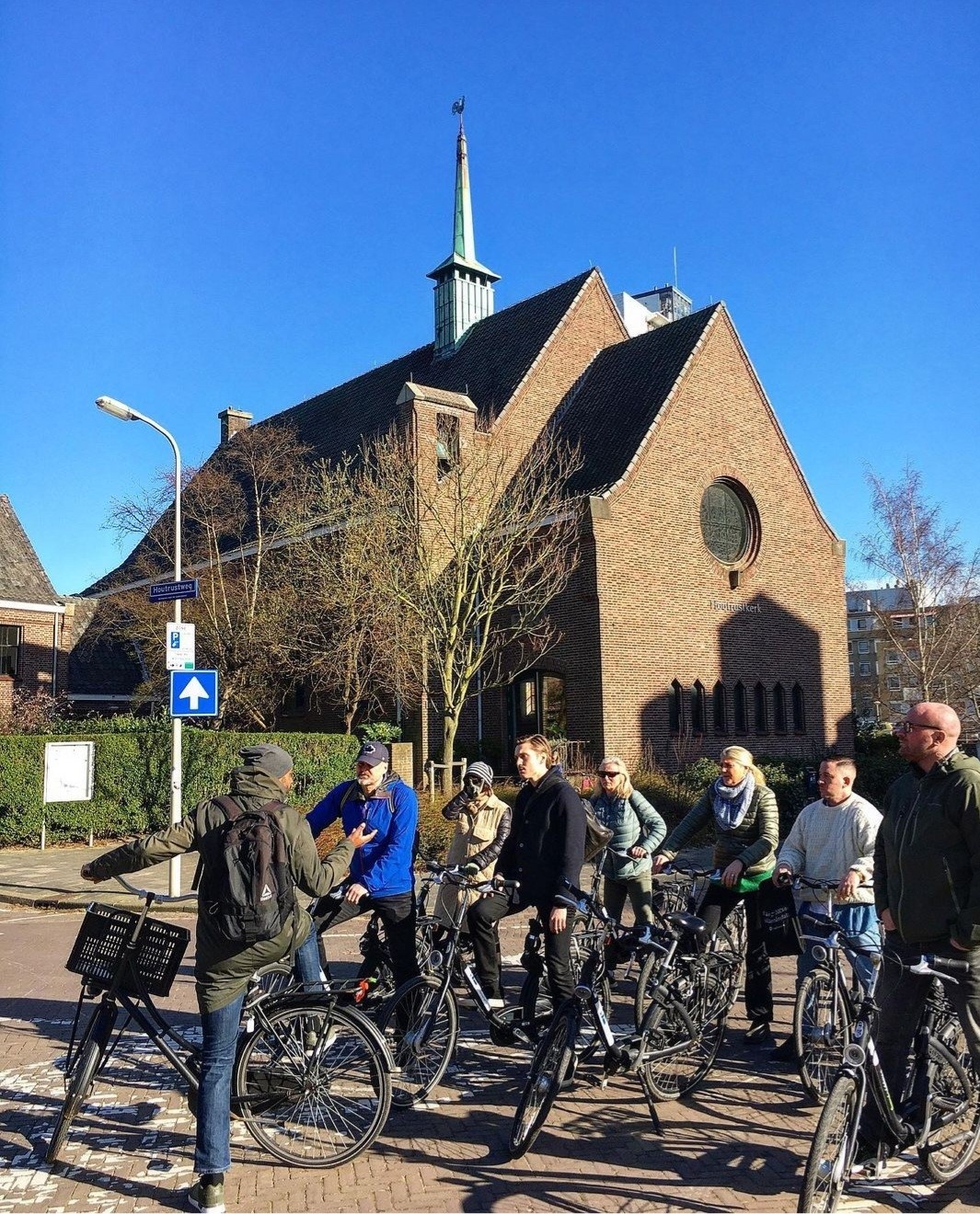 Elever och lärare med cyklar framför kyrka