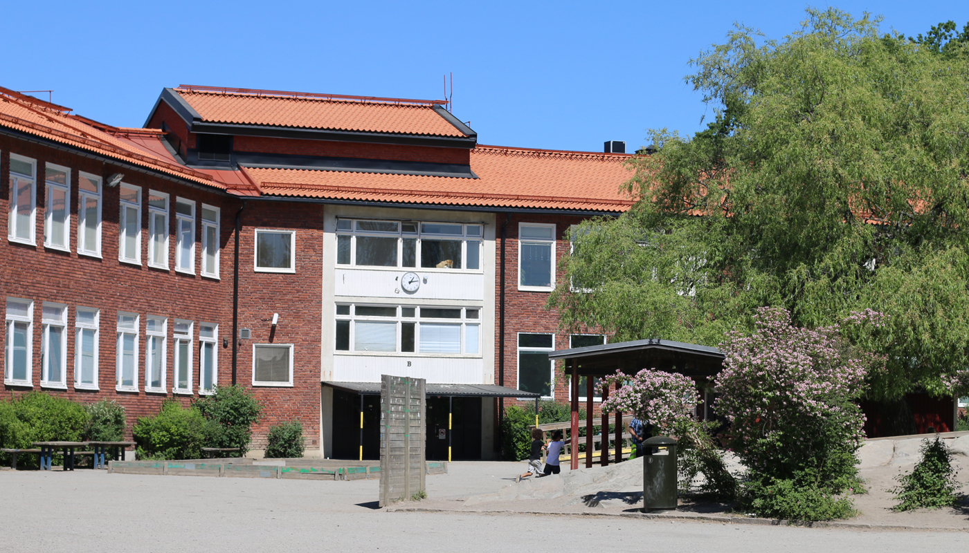 Råsundaskolan. Flervåningshus med träd på skolgården.