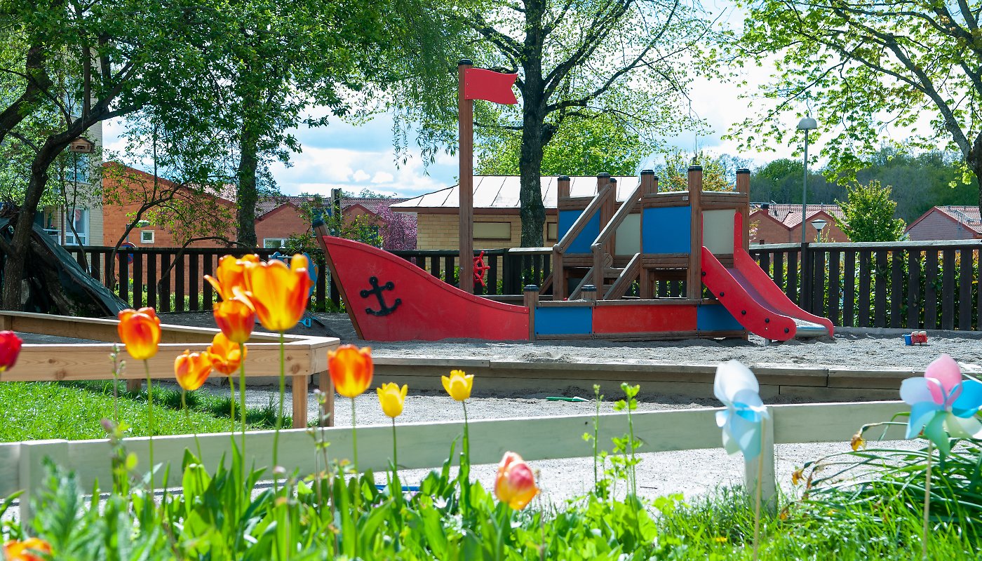 Rågens förskola, utegården med blommor och lekställningar.